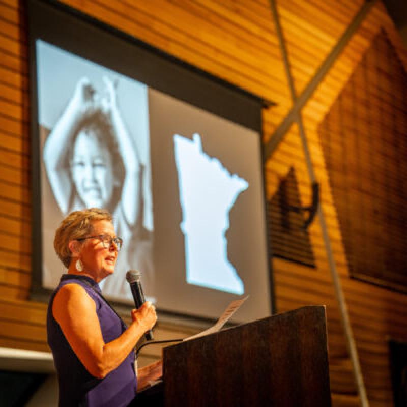 A woman in front of a screen giving a presentation