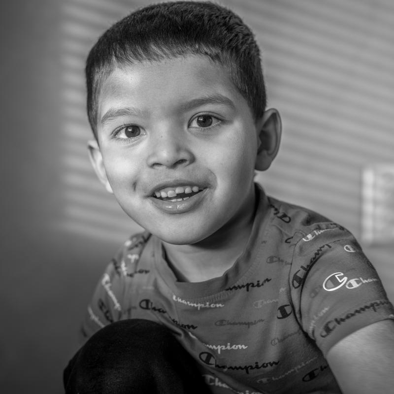 black and white image of a smiling young boy with short brown hair.