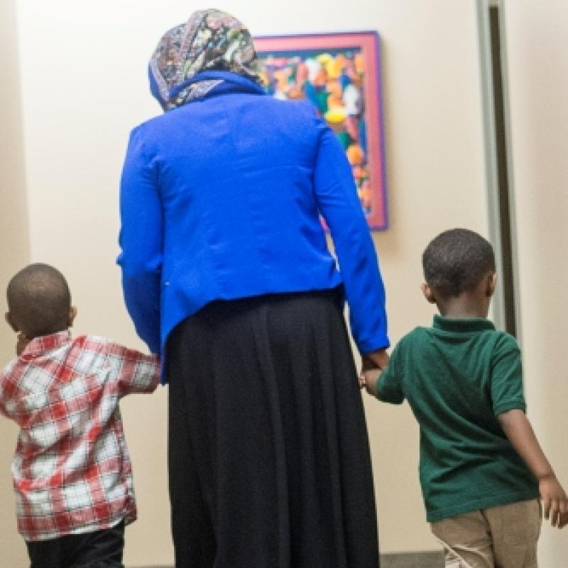 somali woman walking away from camera with two boys