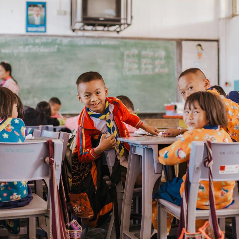 young children smiling in a group in a classroom