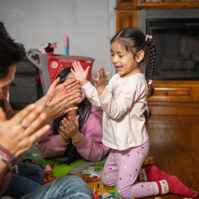 little girl plays and sings with her family 