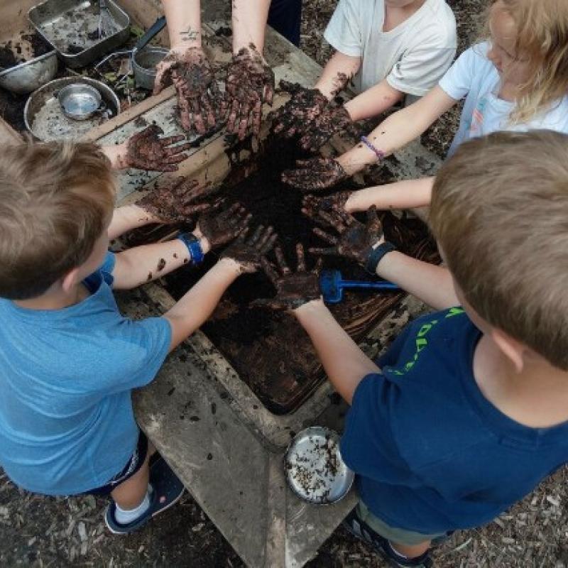 preschool kids getting mud all over their hands