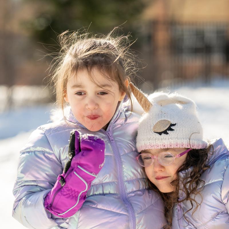 two sisters playing on the playground in the winter